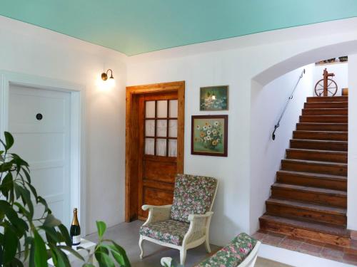 a living room with a chair and stairs at House 1797 - Charm of Slovenian Vintage in Dob