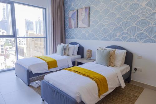 a hotel room with two beds and a window at Art-inspired apartment amidst Downtown Dubai in Dubai