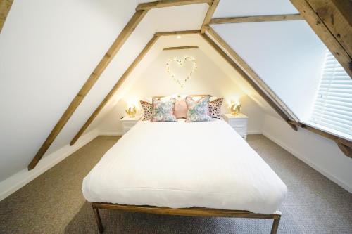 a bedroom with a white bed in a attic at The Wee House by the Sea in Balintore