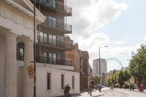 a man walking down a street next to a building at London Serviced Apartments in London