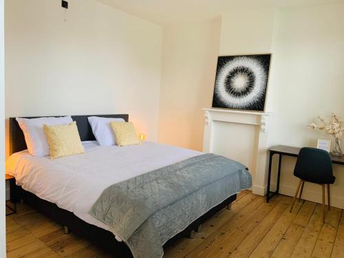 a bedroom with a bed and a painting on the wall at Vakantievilla Leonie in Lo-Reninge