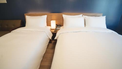 two beds sitting next to each other in a room at Marinabay Sokcho in Sokcho