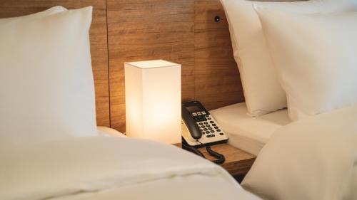 a bedroom with a phone and a light between two beds at Marinabay Sokcho in Sokcho