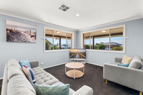 a living room with two couches and a table at Grandview Soldiers Point in Soldiers Point