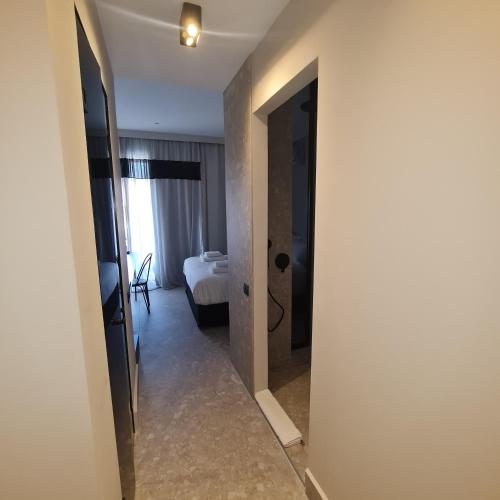 a hallway with a room with a bed and a mirror at Cityzoe Athens Suites in Athens