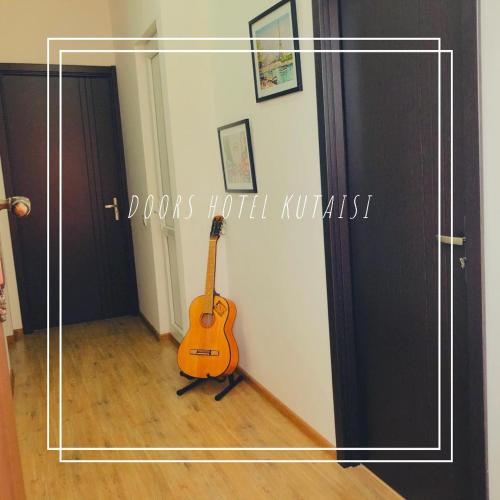 a guitar sitting in a room next to a door at Doors in Kutaisi