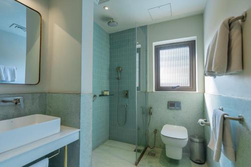 a bathroom with a shower and a toilet and a sink at Amrit Bhawan in Haridwār
