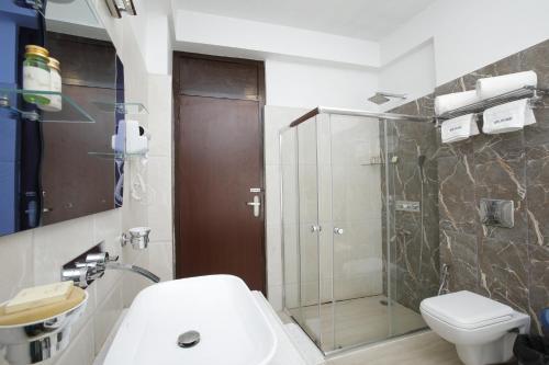 een badkamer met een douche, een wastafel en een toilet bij The Zen Ladakh in Leh