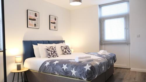 Un dormitorio con una cama con estrellas. en Bedford Town Centre & Elegant Apartment inc PRIVATE Parking en Bedford