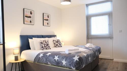 a bedroom with a bed with stars on it at Bedford Town Centre & Elegant Apartment inc PRIVATE Parking in Bedford