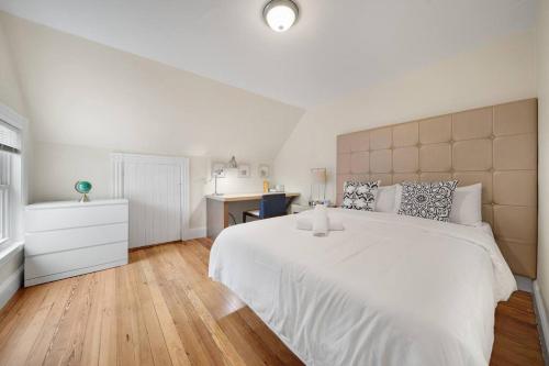 ボストンにある5BR 2BH Bright & Spacious Apt in Brightonの白いベッドルーム(大きな白いベッド1台、デスク付)