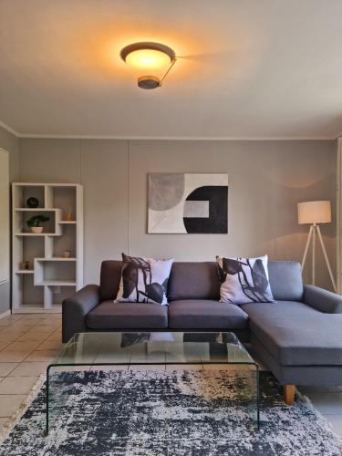 a living room with a couch and a glass table at Island Club by Smart City Stays in Cape Town