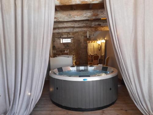 - un bain à remous dans une pièce située entre deux rideaux dans l'établissement Le gîte de Sainte Valière PISCINE,SPA et CLIMATISATION, à Sainte-Vallière