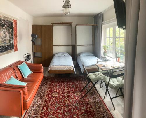 een woonkamer met een bank, een bed en een tafel bij city-apartment een hele verdieping voor jezelf midden in het centrum in Apeldoorn