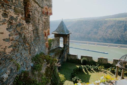 a building with a tower next to a river at Burg Gutenfels in Kaub