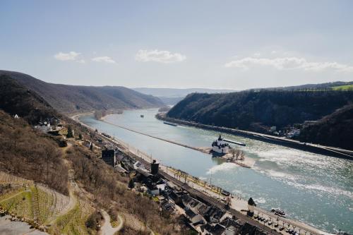 a train is traveling down a river with a trainurrencyternessternessternessstrationterness at Burg Gutenfels in Kaub