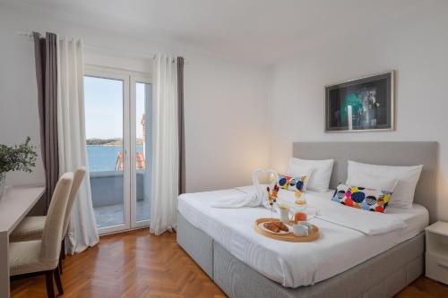 een slaapkamer met een bed en uitzicht op de oceaan bij Villa Nensi in Grebaštica