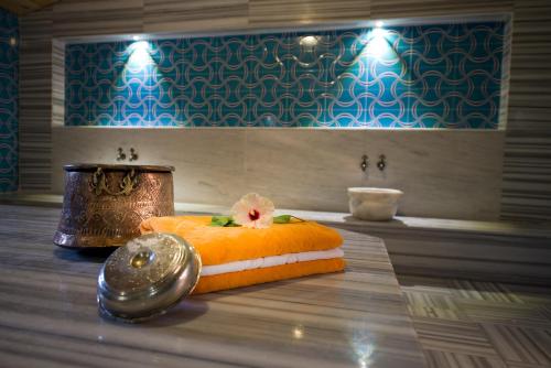 a bathroom with an orange pillow with a flower on it at Kimera Lounge Boutique Hotel & Spa in Cıralı