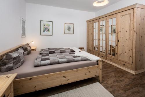 a bedroom with a bed and a wooden cabinet at Villa am First in Oberstdorf