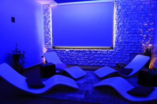 a blue room with blue chairs and a brick wall at Hotel Centrale in Gambarie dʼAspromonte