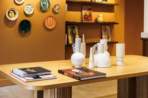 a table with white vases and books on it at Grand Hotel d'Orange, BW Signature Collection in Orange