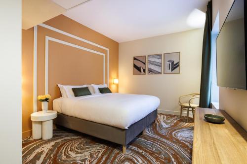 オランジュにあるGrand Hotel d'Orange, BW Signature Collectionのベッドとテーブルが備わるホテルルームです。