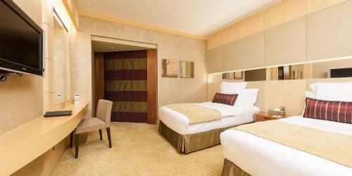 a hotel room with two beds and a flat screen tv at InterContinental Al Khobar by IHG in Al Khobar