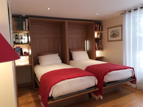 ル・ブール・ドアザンにあるChalet la Cachette Cyclists & Skiersのベッドルーム1室(隣り合わせのベッド2台付)