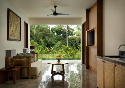 a living room with a couch and a table at Adiwana Suweta in Ubud