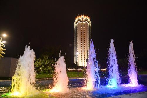 a water fountain in front of a building at night at Kazakhstan Express in Almaty