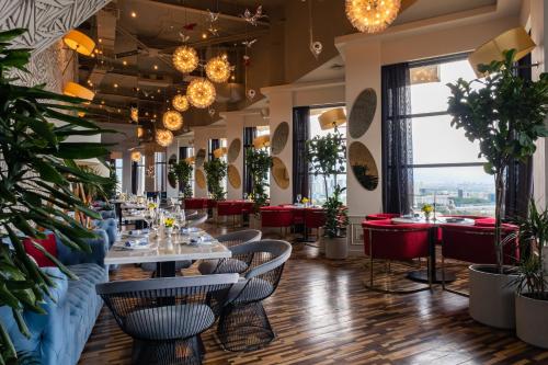 a restaurant with tables and chairs and potted plants at Kazakhstan Express in Almaty