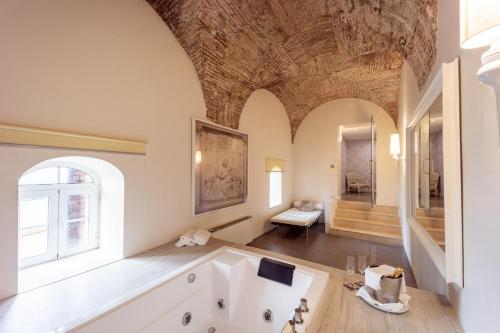 une grande salle de bains avec une grande baignoire et une grande fenêtre. dans l'établissement Palacio São Silvestre-Boutique Hotel, à Coimbra