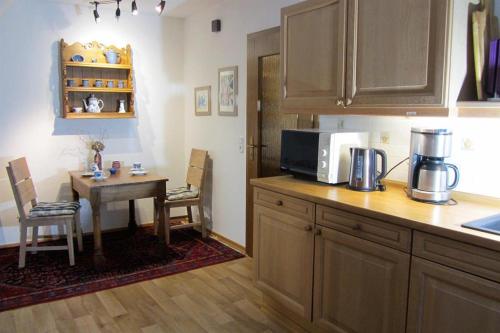 eine Küche mit einem Tisch und einer Mikrowelle sowie einem Tisch mit einem Tisch in der Unterkunft Ferienwohnung Meier-Althof in Bad Salzuflen