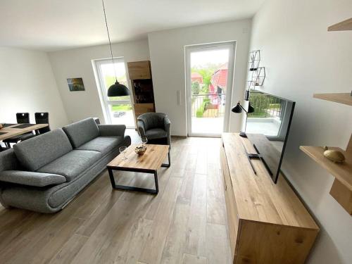 a living room with a couch and a table at Ferienwohnung Tor zum Meer - Neubau mit Sauna, Fahrstuhl und Tiefgarage in Kühlungsborn