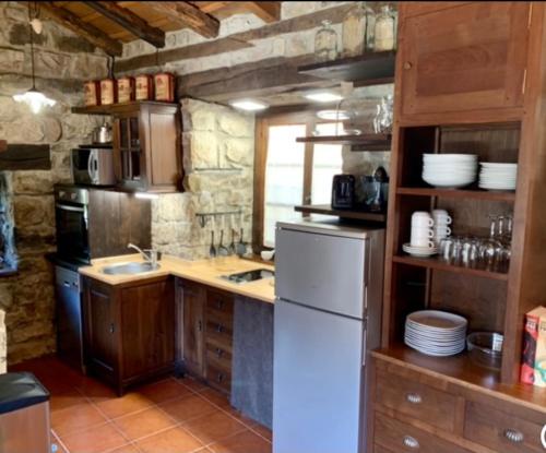 a kitchen with a white refrigerator and a sink at La Casita de Cuestallano in Renedo