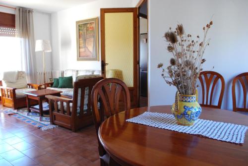 una mesa de comedor con un jarrón de flores. en Can Lladoner en Sant Llorenc de Morunys