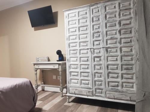 uma grande parede de madeira com muitas gavetas num quarto em Hostal Pabellón em O Grove