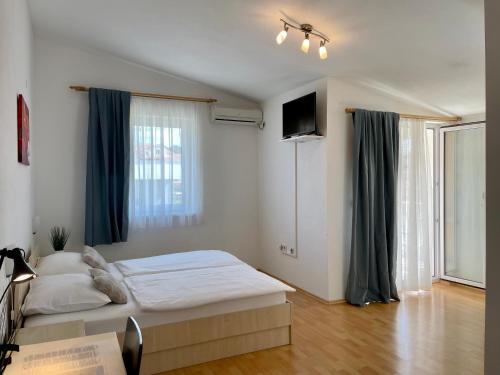 1 dormitorio con 1 cama y TV en Rooms and Apartments Ana, en Zadar