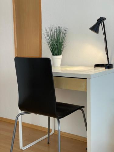 una silla negra sentada frente a un escritorio con una planta en Rooms and Apartments Ana, en Zadar
