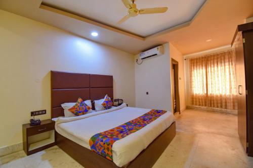 a bedroom with a large bed and a ceiling fan at FabHotel Red Rose in Amingaon