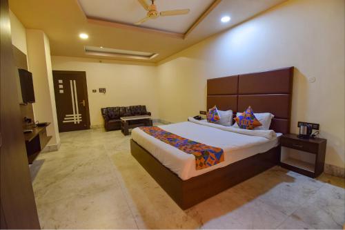 a bedroom with a large bed and a couch at FabHotel Red Rose in Amingaon