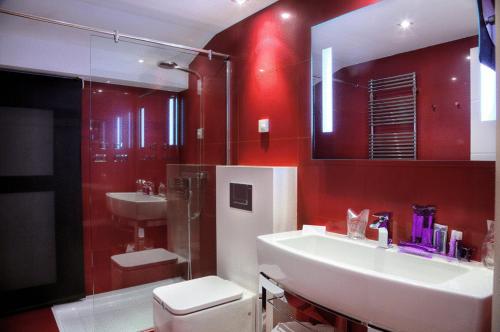 baño con 2 lavabos y pared roja en San Ramón del Somontano, en Barbastro