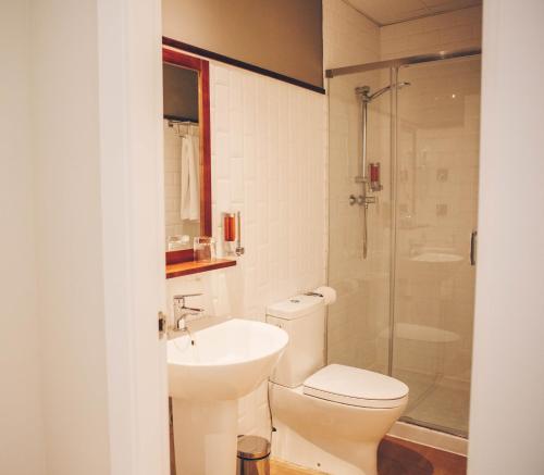 
a bathroom with a toilet, sink, and shower at Alcazaba Premium Hotel in Málaga
