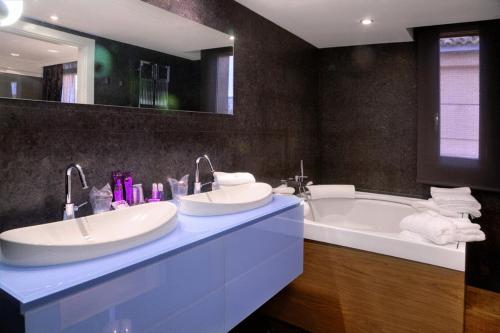 a bathroom with two sinks and a bath tub at San Ramón del Somontano in Barbastro