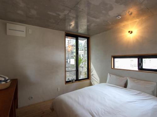 那覇市にあるON THE SAME HOTEL-All suite-のベッドルーム(大きな白いベッド1台、窓付)