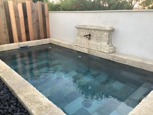 une piscine d'eau bleue dans une clôture dans l'établissement La maison de Flore, à Pernes-les-Fontaines