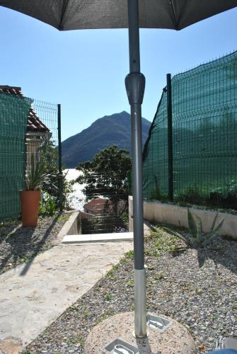 a pole of an umbrella with a mountain in the background at Casa Mediterraneo Perast in Perast
