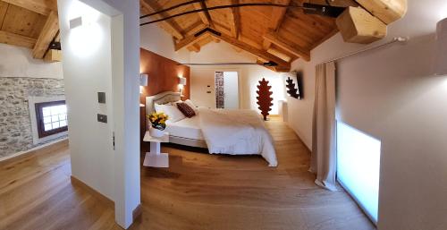 a bedroom with a large bed and wooden ceilings at Corte degli OstiNati in Variano