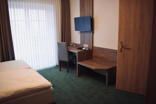 ein Hotelzimmer mit einem Schreibtisch und einem Bett in der Unterkunft Schützenhof Ahlerstedt in Ahlerstedt