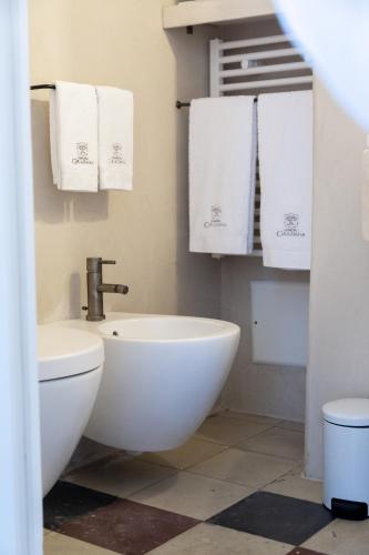 a bathroom with a toilet and a sink and towels at Dimora Graziana 1909 in Locorotondo